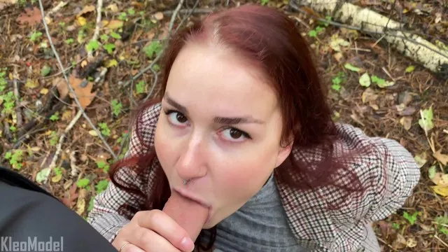 Red-haired girl in coat gives park blowjob